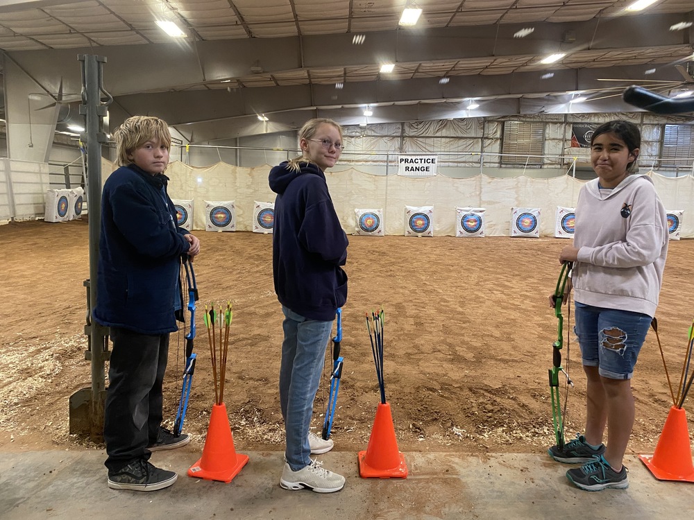 Three students at the archery range
